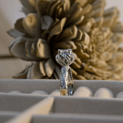 Diamond ring in a box with decorative flowers in the background