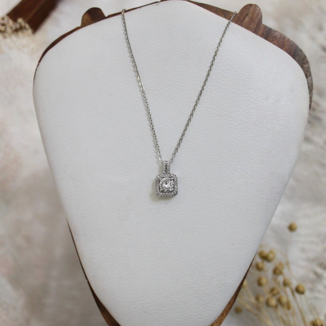 Silver necklace with a pendant on a white jewelry display