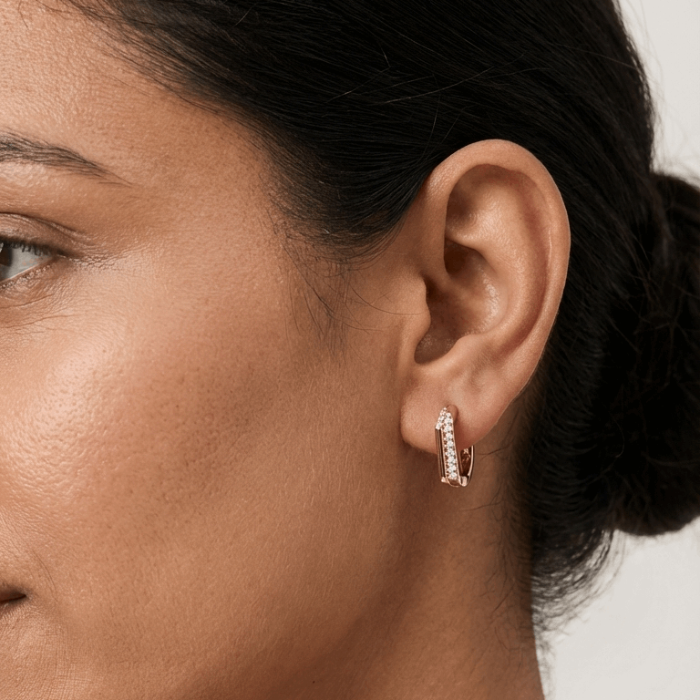 Close-up of a woman wearing a hoop earring with a neutral background