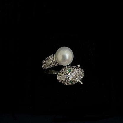 Luxury diamond ring with pearl and emerald accents, animal head design on black background