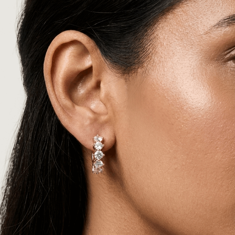 Close-up of a woman wearing diamond earrings with a neutral background