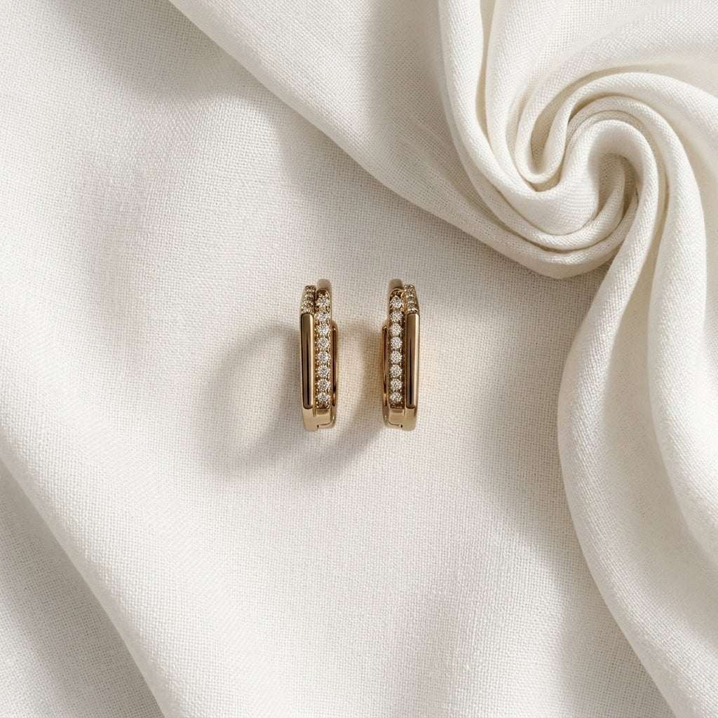 Champagne Gold hoop earrings with small diamonds on a white fabric background