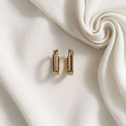 Champagne Gold hoop earrings with small diamonds on a white fabric background